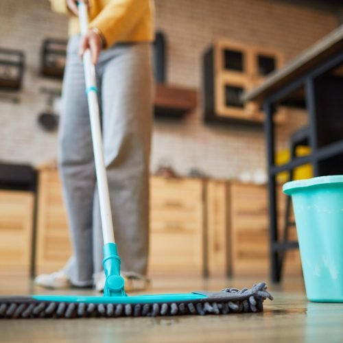 Woman Cleaning Floors at Home Close up background of unrecognizable woman mopping floors while cleaning cozy apartment, copy space